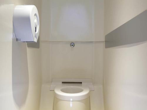 a white bathroom with a toilet with a paper dispenser at hotelF1 Avignon Centre Courtine gare TGV in Avignon