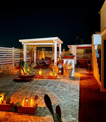a patio at night with a gazebo and fire pits at Kasa Celeste Aida in Gallipoli