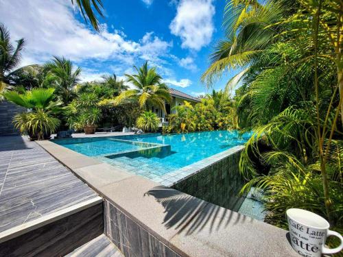 a swimming pool in a villa with palm trees at sengjan garden krabi in Ban Khlong Son