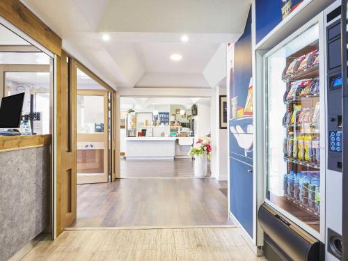 a grocery store aisle with a refrigerator and a pharmacy at ibis budget Santeny in Santeny