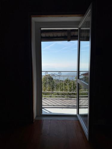 an open door to a balcony with a view of the ocean at La tana del Lupo in Rubiana