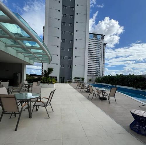 a patio with tables and chairs next to a building at Apartamento Torre Lumiar 3 quartos COP 30 e CIRIO in Belém