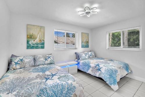 a bedroom with two beds and a fan and windows at Costerra Miami 2BR in Miami