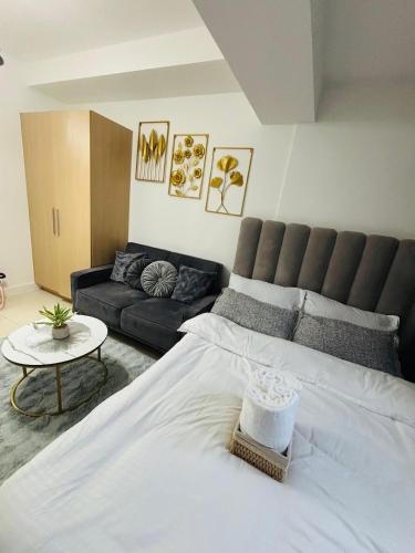 a bedroom with a large white bed and a couch at L Studio by Sella in Manila