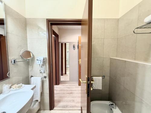 a bathroom with a sink and a toilet and a tub at Hotel Castello Artemide Congressi in Castel San Pietro Terme