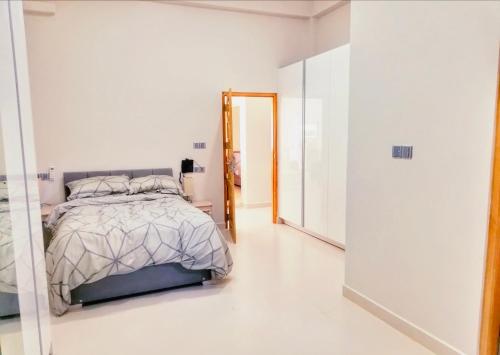 a white bedroom with a bed and a mirror at Regus Jaffna in Jaffna