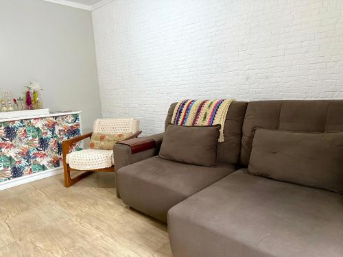 a living room with a couch and a chair at Paraíso na praia 800 mts do mar in Imbé