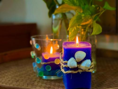 a candle sitting on a table with a vase at Paraíso na praia 800 mts do mar in Imbé