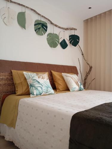 a bedroom with a bed with leaves on the wall at Mirante Monte e Mar in Esposende