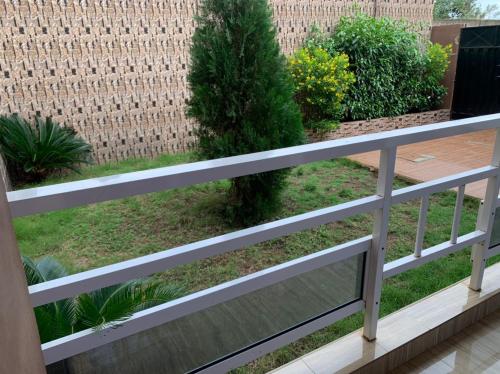 a fence with a tree in a garden at Villa de 3 appartements in Porto-Novo