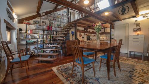 a dining room with a wooden table and chairs at Dolomites Luxury Penthouse in Agordo