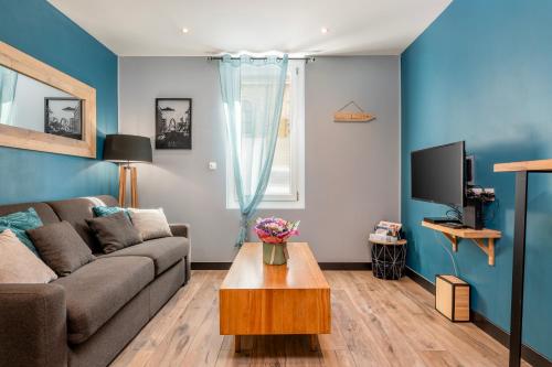 a living room with a couch and a table at OFFRE octobre Le Cosy Studio, idéal pro ou couple, proche de la plage in Le Havre