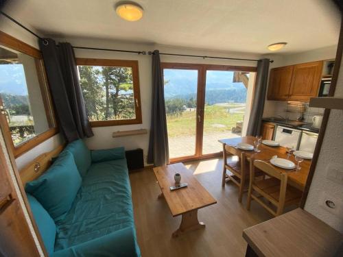 a living room with a blue couch and a table at Les Chalets De Superd Bleuet - 2 Pièces pour 4 Personnes MAE-8884 in Le Dévoluy