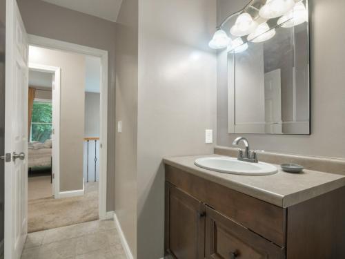 a bathroom with a sink and a mirror at Killington Terrace Lodge - Spacious 5BR Killington Home with 2 Kitchens, Game Room & Pet Friendly in Sherburne Center
