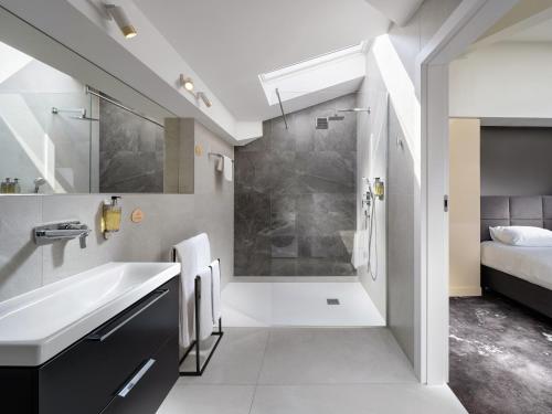 a bathroom with a shower and a sink at Mamaison Residence Diana in Warsaw