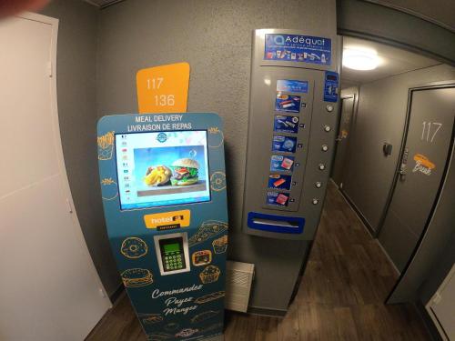 a vending machine in an elevator with a sign at hotelF1 Paris Villemomble in Villemomble