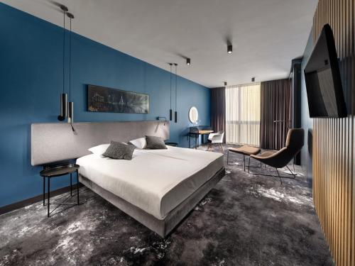 a bedroom with a large bed and a blue wall at Mamaison Residence Diana in Warsaw