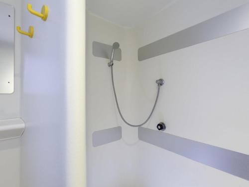 a shower with a hose attached to a wall at hotelF1 Saint-Die in Saint Die