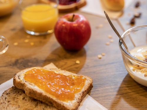 a piece of bread with jam and an apple on a table at hotelF1 Saint-Die in Saint Die