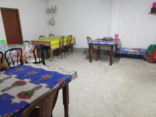 ein Zimmer mit Tischen und Stühlen in einem Zimmer in der Unterkunft EHI Homestay Rishop in Rishop