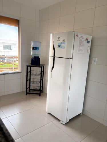 a white refrigerator in a room with a window at Villa das Águas - Praia do Saco - OT in Estância
