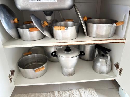 a bunch of pots and pans on a shelf at Villa das Águas - Praia do Saco - OT in Estância