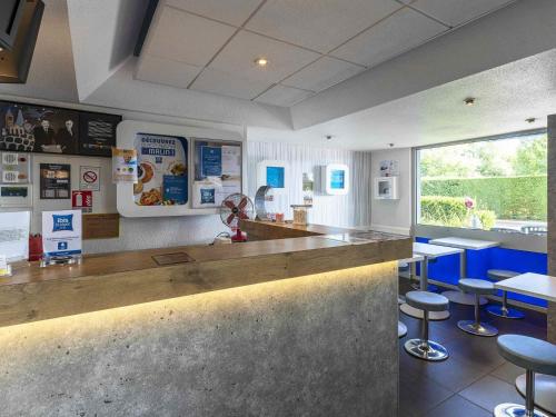 a fast food restaurant with a counter and stools at Hotel Ibis Budget Vichy in Bellerive-sur-Allier