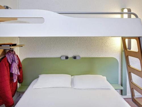 a bunk bed with two white pillows in a room at Hotel Ibis Budget Vichy in Bellerive-sur-Allier