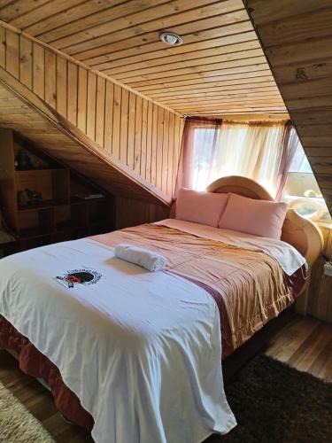 a bedroom with a bed in a wooden house at Hostería Cabañas del Pescador in Cuenca