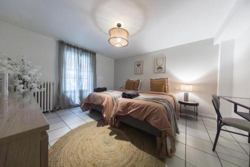 a bedroom with a bed and a table and a window at Loft Station Parking Video Projector near Tours in Saint-Pierre-des-Corps