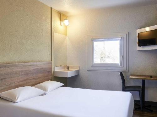 a bedroom with a bed and a sink and a window at hotelF1 Evry A6 in Evry-Courcouronnes