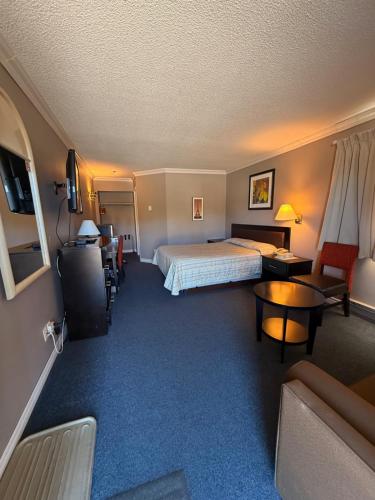 a hotel room with a bed and a couch at Motel Au Bercail in Temiscaming