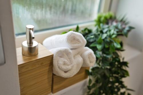 a pile of towels sitting on a bathroom sink at Comfort Lettings - 4 bedroom, 8 Beds & 2 Free Parking, Garden, Family and Workers Friendly in Market Harborough