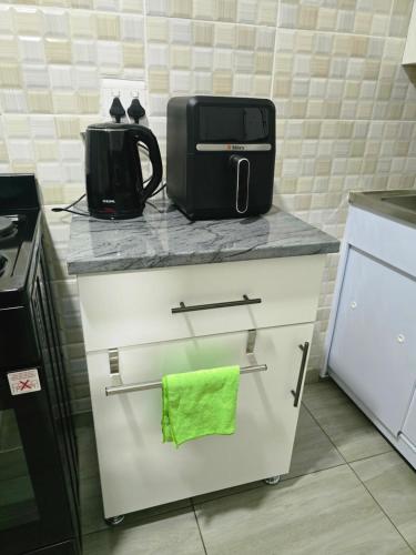 a kitchen with a microwave and a green towel on a counter at Peshline Guest House Unit 3 in Ermelo