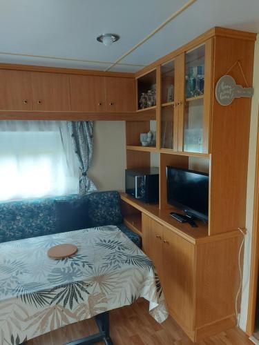a bedroom with a bed and a desk with a tv at Au refuge de Lahontan in Castelnau-dʼAuzan