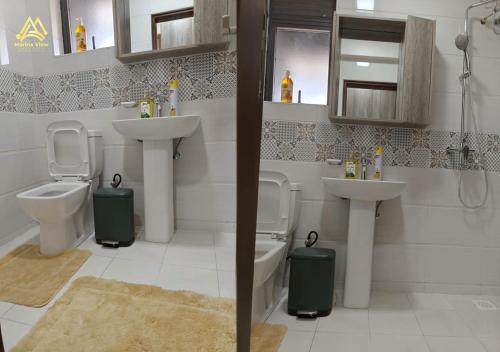 a bathroom with two sinks and two toilets at Marina View Luxury Suites Munyonyo Kampala in Kampala