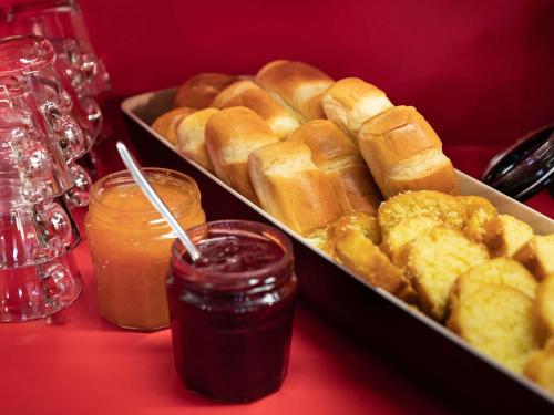 a tray of bagels and sauce on a red table at hotelF1 Le Mans Nord in Saint-Saturnin
