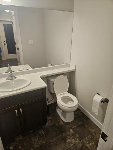 a bathroom with a white toilet and a sink at Comfy Home in Harbour Landing - Regina in Regina