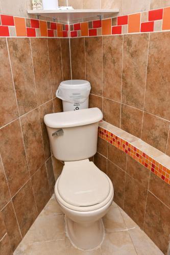 a bathroom with a white toilet in a tiled wall at Hotel Campestre Villa Ocha in Valledupar
