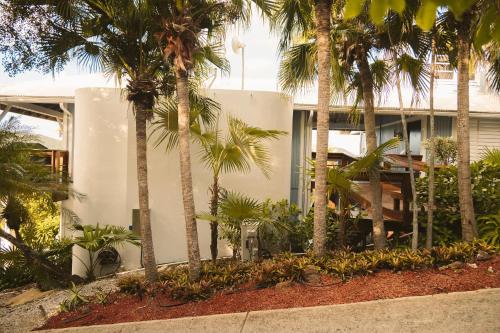 a white building with palm trees in front of it at Oceania Villas in Culebra