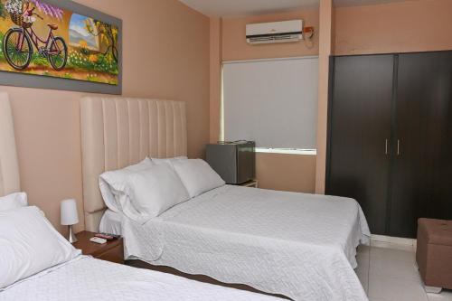 a hotel room with two beds and a window at Hotel Campestre Villa Ocha in Valledupar