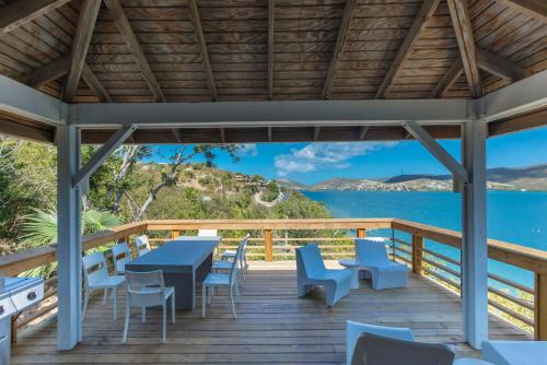 a deck with tables and chairs and a view of the water at Oceania Villas in Culebra