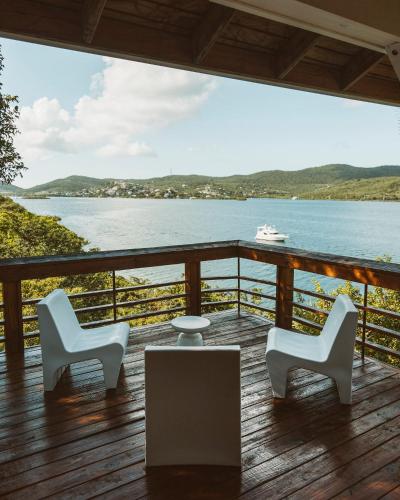 two chairs and a table on a deck overlooking the water at Oceania Villas in Culebra