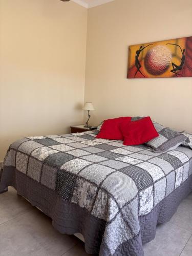 a bedroom with a bed with a checkered blanket at La Casita del Golf in Sierra de la Ventana