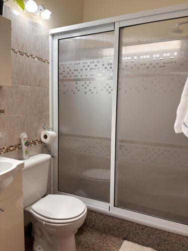 a bathroom with a shower with a toilet and a sink at La Casita del Golf in Sierra de la Ventana