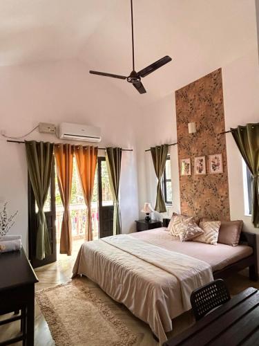 a bedroom with a bed and a ceiling fan at Alaansh Villa Perfect Backyard & BBQ Retreat in Assagao