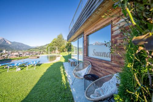 a building with a patio with chairs and a pool at Im Kranzhof in San Candido