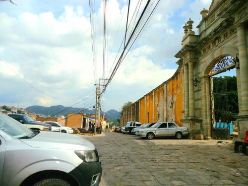 a street with cars parked next to a building at El Bello Jardín de Chela in Guanajuato