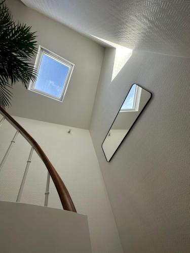 a staircase with a mirror and a window on the ceiling at Charmant appartement vincennes in Vincennes