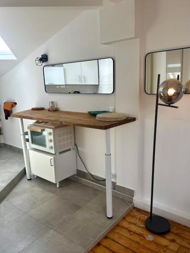 a kitchen with a desk with a microwave and a lamp at Charmant appartement vincennes in Vincennes